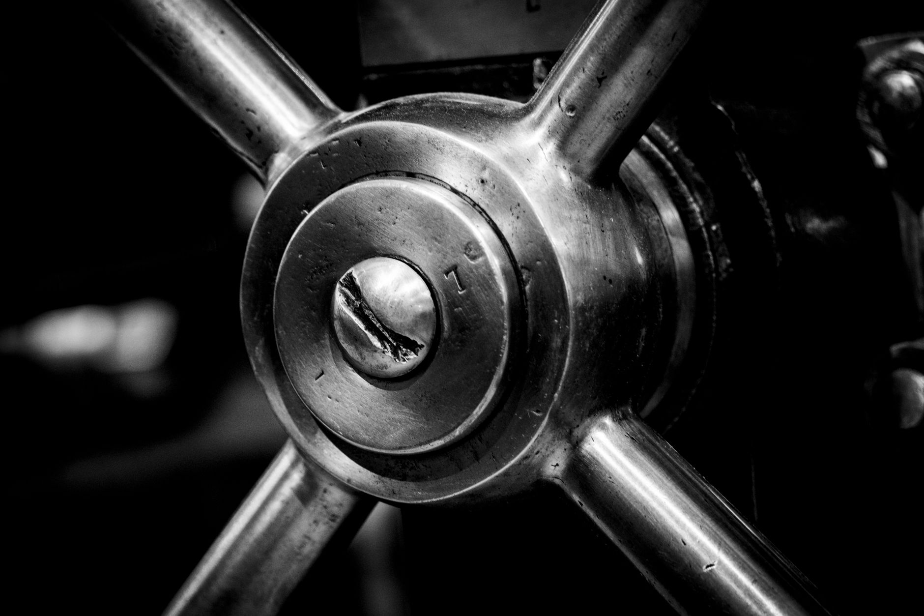 Detailed black and white image of an industrial metal cog showcasing intricate machinery design.