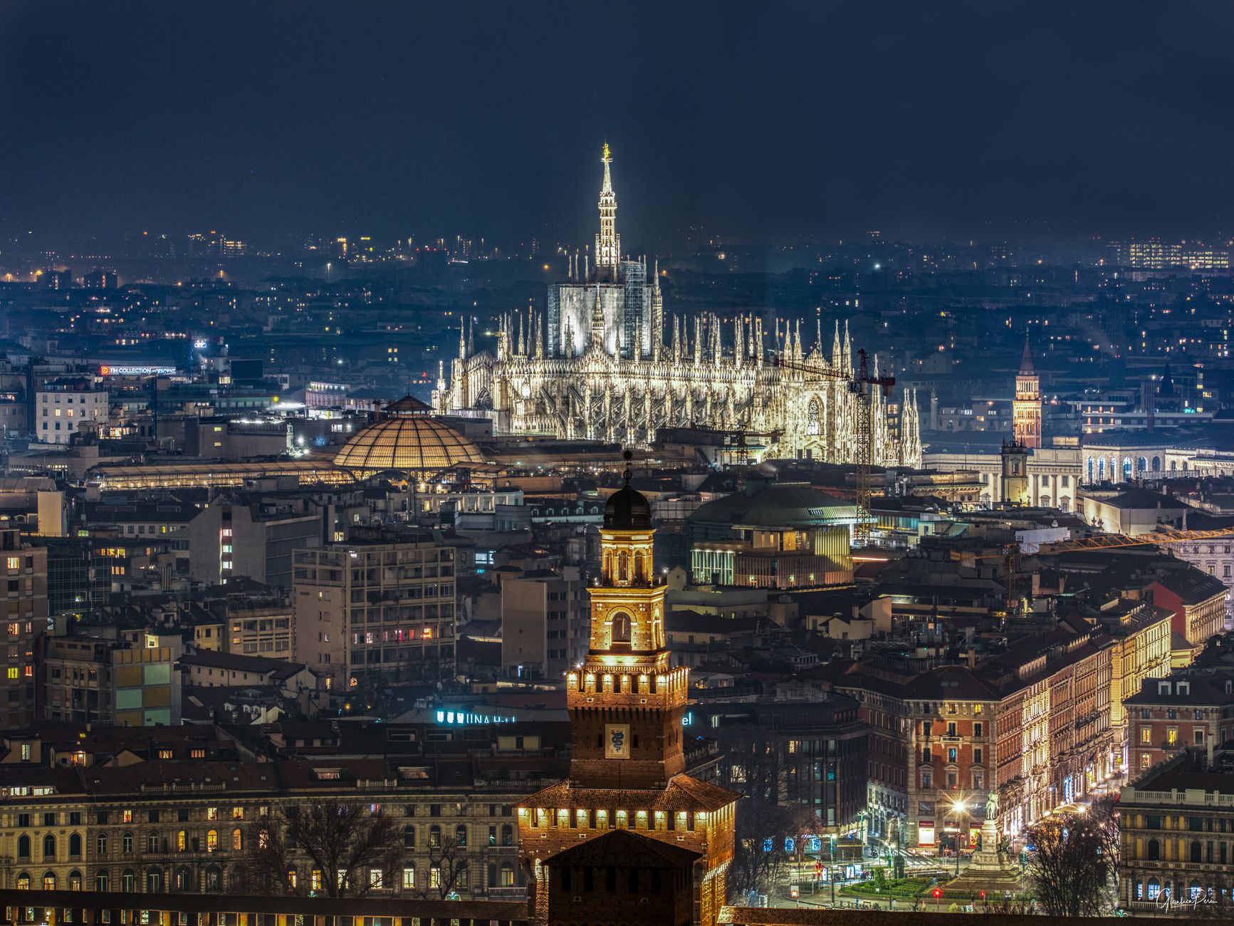 Stunning aerial night view of Milan featuring the illuminated Duomo Cathedral and cityscape.