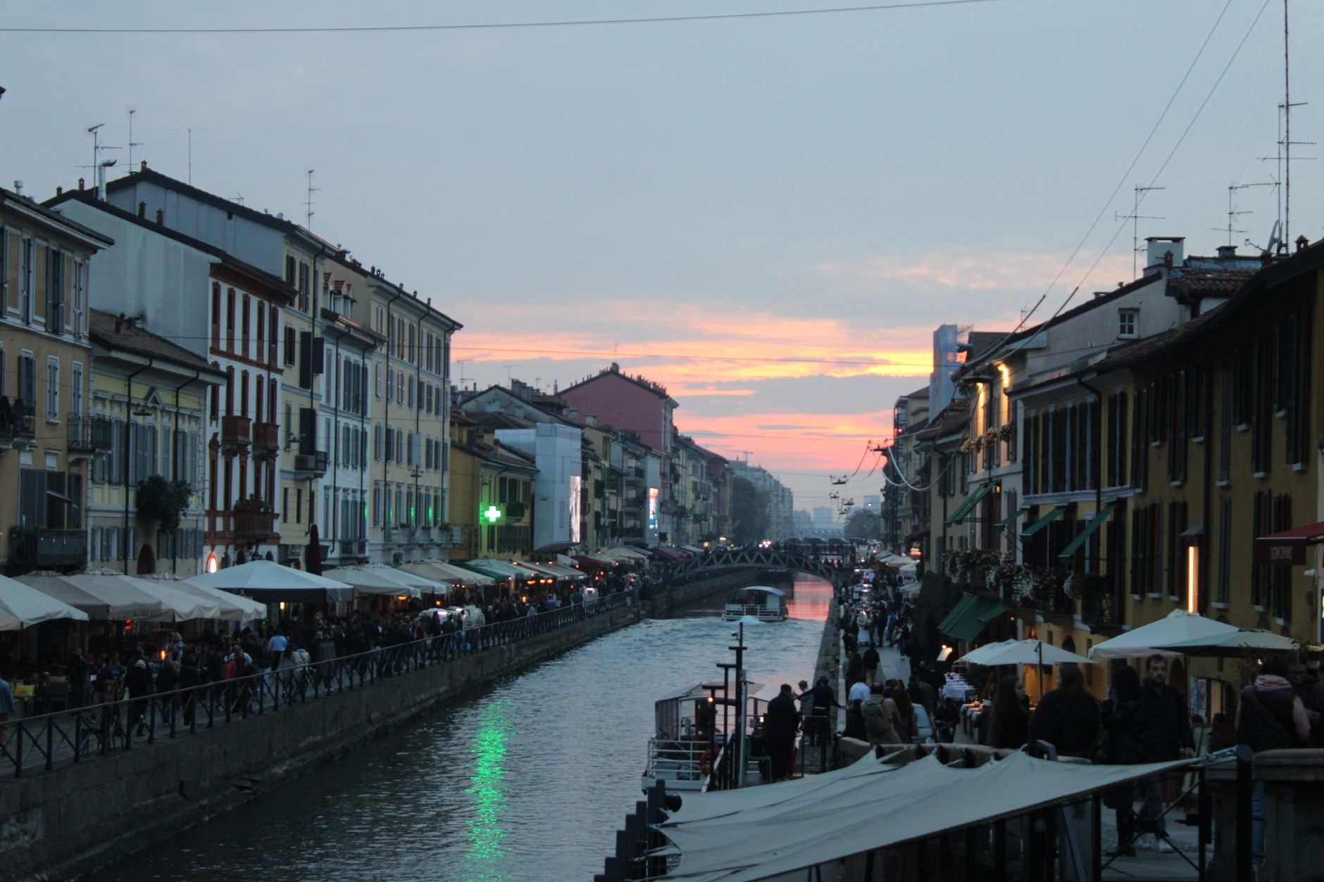 Bustling evening at Naviglio Grande in Milan during sunset.