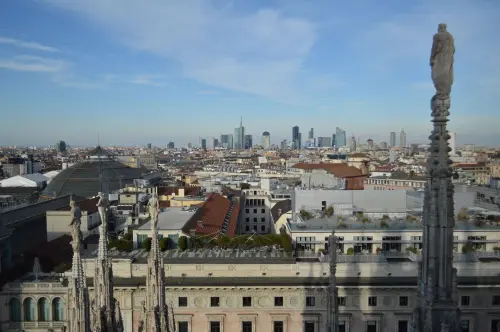 Captivating aerial view of Milan's skyline from atop the Duomo with a clear blue sky backdrop.