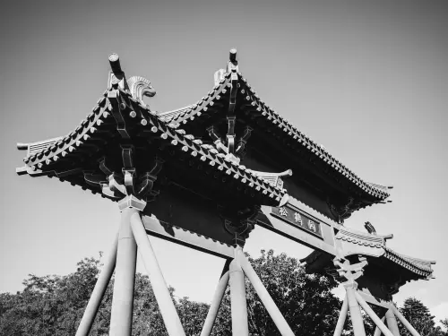A stunning black and white image of a traditional Chinese gate showcasing intricate architectural details.