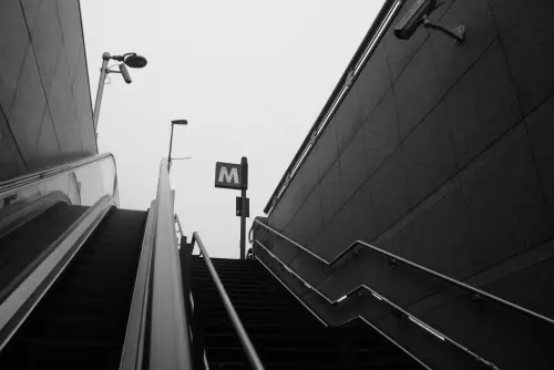 A monochromatic view of an escalator leading to a subway station in Turin, Italy.