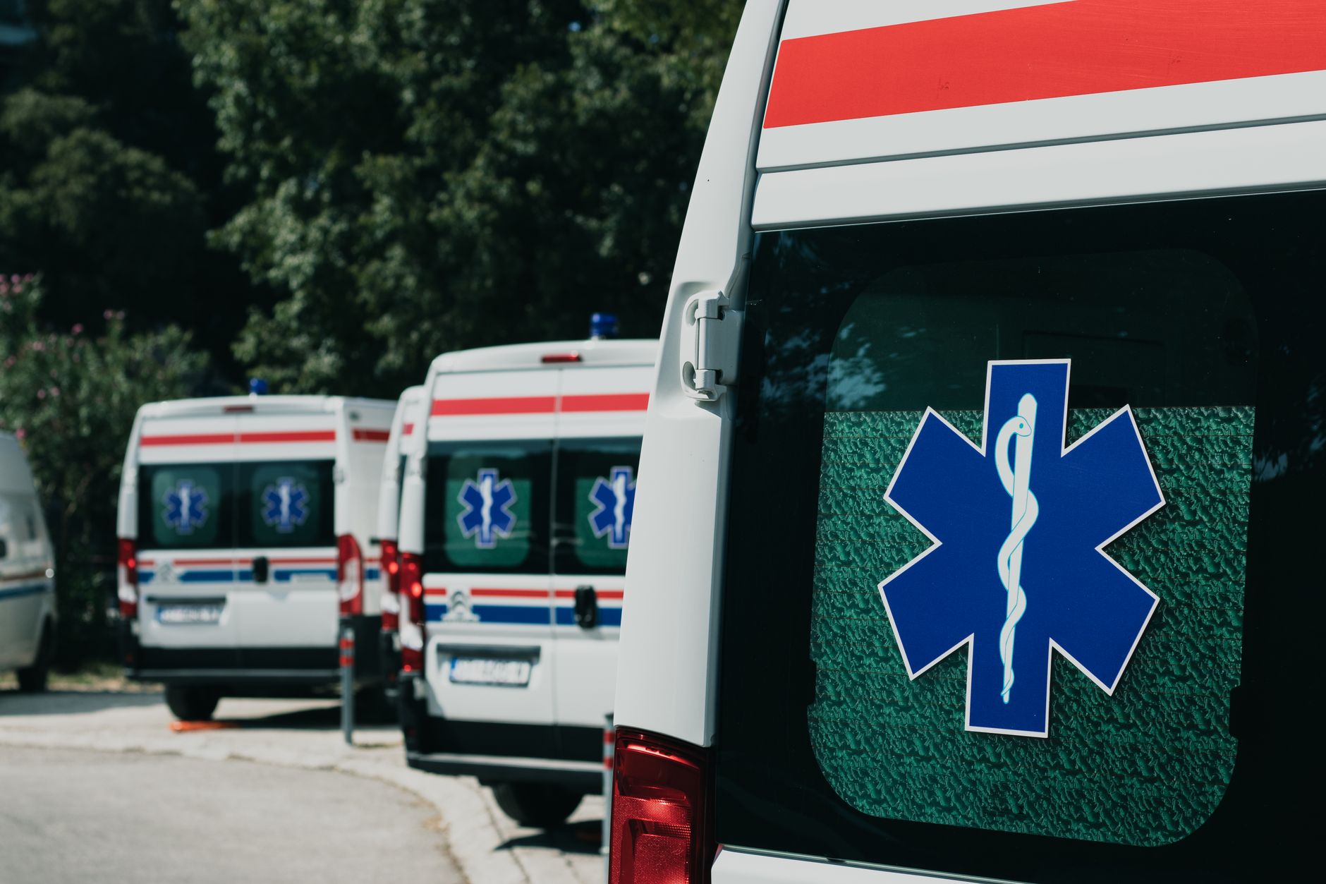 Three ambulances parked outdoors, ready for emergency healthcare situations.