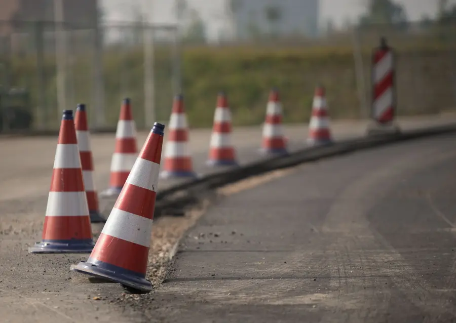 Line of traffic cones on a road under construction, indicating warning and caution.