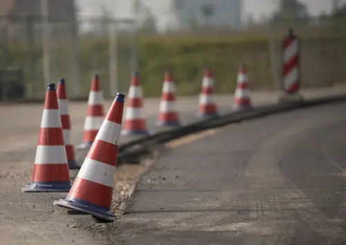 Line of traffic cones on a road under construction, indicating warning and caution.