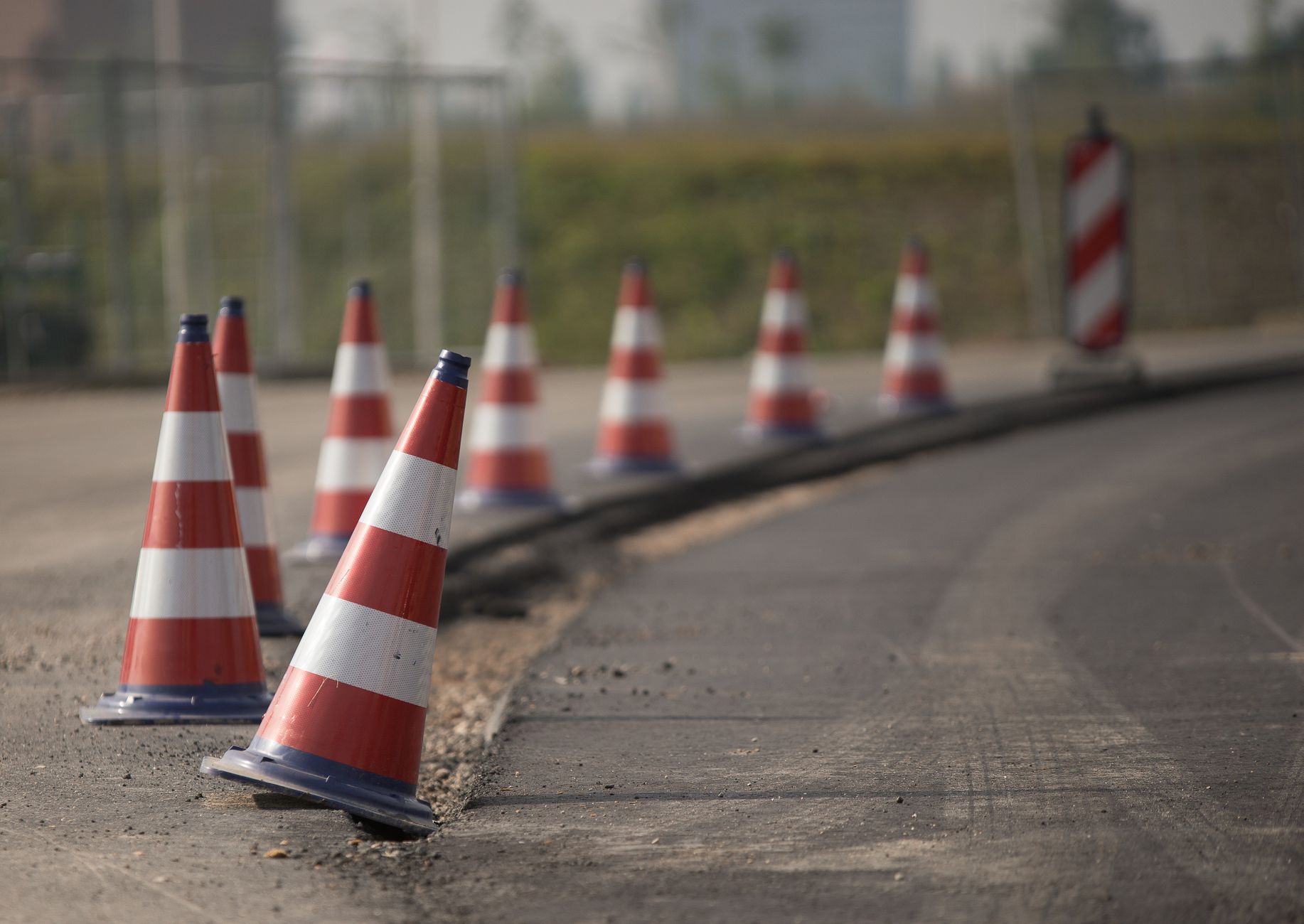 Line of traffic cones on a road under construction, indicating warning and caution.