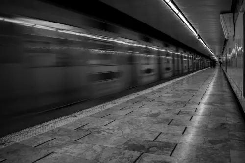 Dramatic black and white shot of a moving subway train in Mexico City.