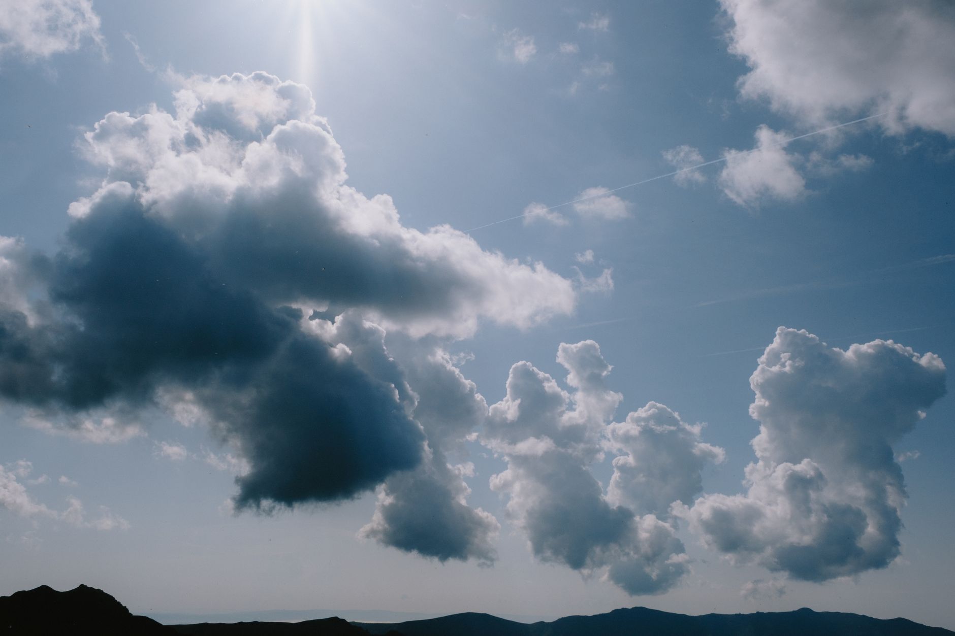A peaceful sky with fluffy clouds illuminated by sunlight, creating a tranquil atmosphere.