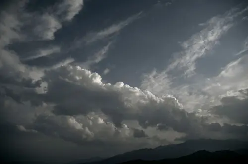 Moody cloudscape with dramatic overcast clouds over distant mountains.